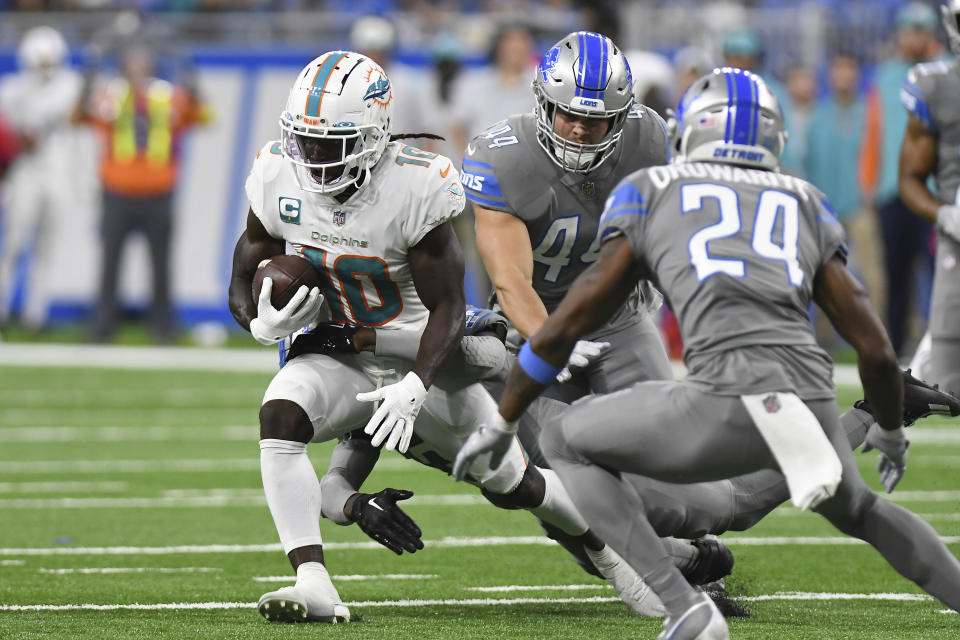Miami Dolphins wide receiver Tyreek Hill (10) rushes by Detroit Lions cornerback Amani Oruwariye (24) and linebacker Malcolm Rodriguez (44) during the first half of an NFL football game, Sunday, Oct. 30, 2022, in Detroit. (AP Photo/Lon Horwedel)