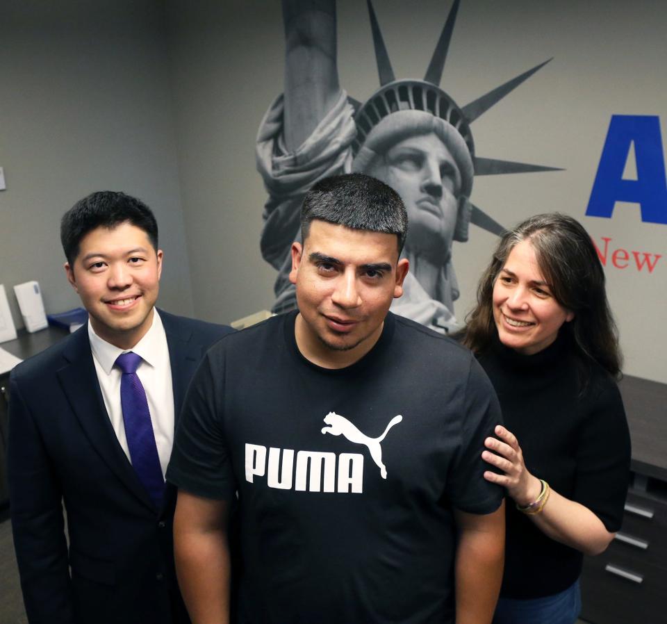 José Daniel Guerra-Castañeda poses at the New Hampshire ACLU office in Concord with attorneys Sang Yeob Kim, left, and Nina Froes on May 11, 2022.