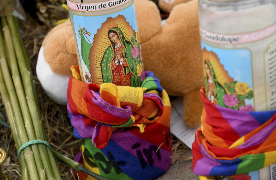 Religious votive candles are wrapped in gay pride rainbow colors at a memorial outside Club Q in Colorado Springs, Colo., on Wednesday, Nov. 23, 2022. Five people were killed when a gunman opened fire at the club Saturday night. The shooting has raised uneasy questions about the lasting legacy of cultural conflicts that caught fire decades ago and gave Colorado Springs a reputation as a cauldron of venomous religion-infused conservatism, where LGBTQ people didn't fit in with the most vocal community leaders' idea of family values. (AP Photo/Thomas Peipert)