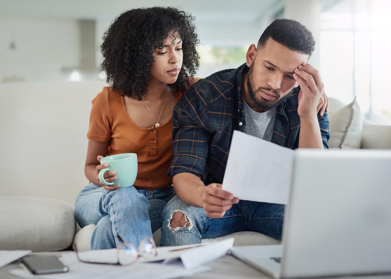 Shot of a young couple looking stressed while going over their finances at home