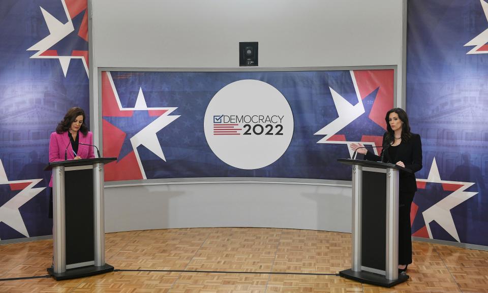 Michigan Gov. Gretchen Whitmer, left, takes notes as Republican candidate Tudor Dixon speaks during a debate televised on WXYZ Channel 7 at Oakland University in Rochester, Mich., on Tuesday, Oct. 25, 2022.