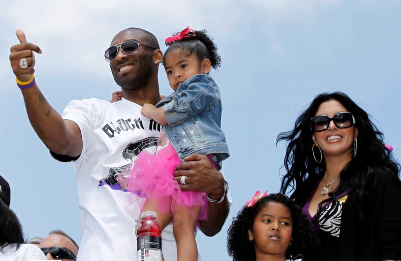 FILE PHOTO: Bryant carries his daughter Gianna, as Vanessa and daughter Natalia stand next to him during the NBA Championship parade in Los Angeles