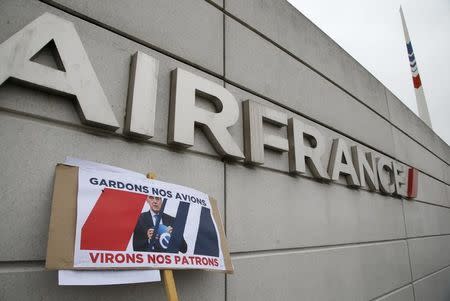 A board with an image of Air France-KLM Chief Executive Officer Alexandre de Juniac reading "keep our planes, sack the bosses" is seen on the Air France headquarters building at the Charles de Gaulle International Airport in Roissy, near Paris, France, October 5, 2015. REUTERS/Jacky Naegelen