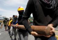 <p>Opposition supporters carry materials to build a barricade to block an avenue while rallying against President Nicolas Maduro in Caracas, Venezuela, May 15, 2017. (Carlos Garcia Rawlins/Reuters) </p>