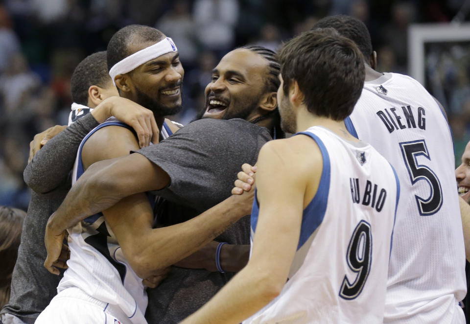 Minnesota Timberwolves forward Corey Brewer, left, celebrates with teammates Ronny Turiaf, center, of France; Ricky Rubio (9), of Spain; and Gorgui Dieng (5) after the Timberwolves defeated the Houston Rockets 112-110 in an NBA basketball game in Minneapolis, Friday, April 11, 2014. (AP Photo/Ann Heisenfelt)