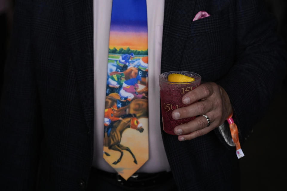 A race fan holds a drink as he walks on the grounds of Churchill Downs before the 150th running of the Kentucky Oaks horse race Friday, May 3, 2024, in Louisville, Ky. (AP Photo/Charlie Riedel)