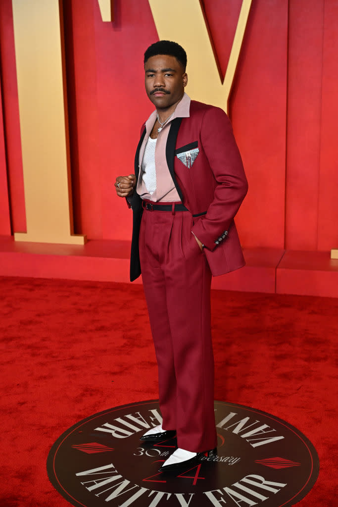 Man in a stylish suit with contrast lapel posing on Vanity Fair event carpet