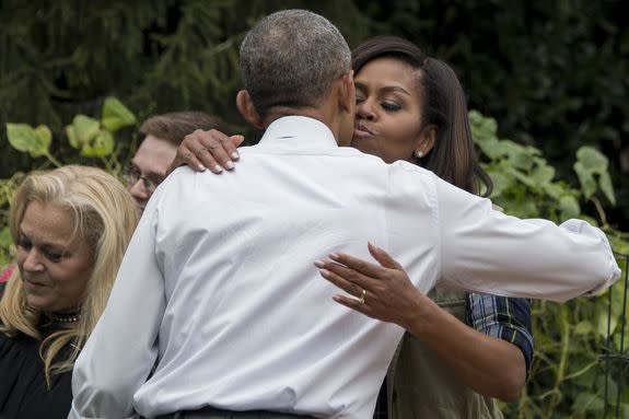 US President Barack Obama (C) receives a kiss from First Lady Michelle Obama as he visits the White House Kitchen Garden during a harvesting event at the White House in Washington, DC, October 6, 2016. / AFP / JIM WATSON        (Photo credit should read JIM WATSON/AFP/Getty Images)