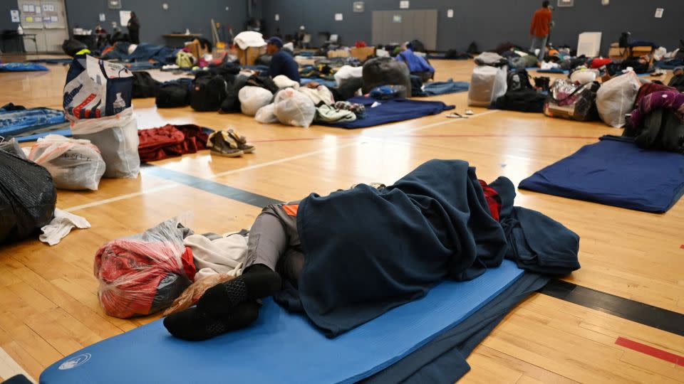 A migrant lies on the sleeping pad at a makeshift shelter in Denver on January 13, 2023. - Hyoung Chang/Pool/Reuters