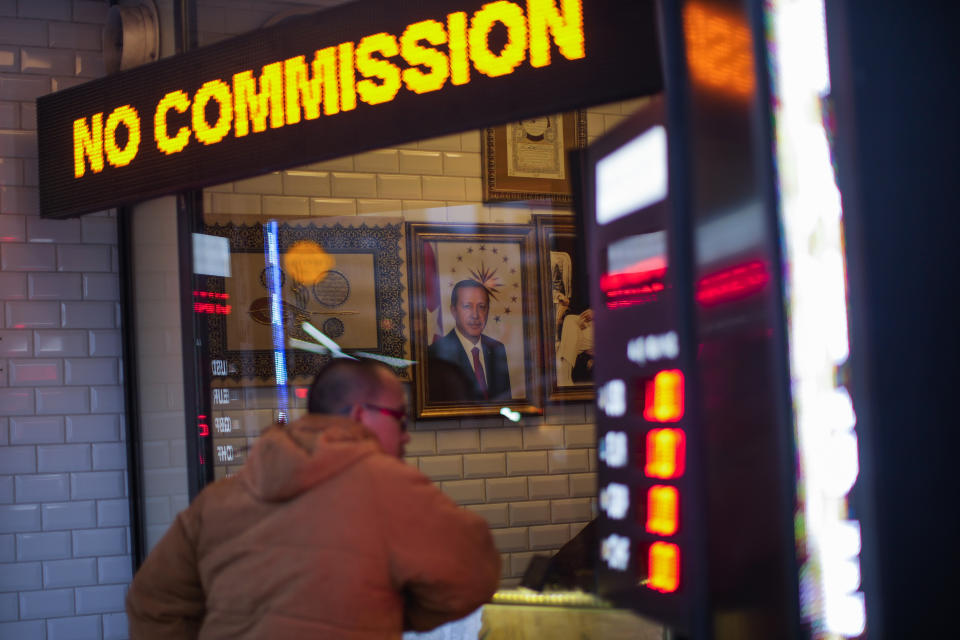 A portrait of Turkey's President Recep Tayyip Erdogan hangs in a money exchange shop in Istanbul, Turkey, Monday, Dec. 20, 2021. Turkey's government and central bank have taken a series of complex steps in recent weeks to prop up a beleaguered economy crippled by skyrocketing consumer prices, instead of ending a much-criticized plan to cut interest rates. (AP Photo/Francisco Seco)