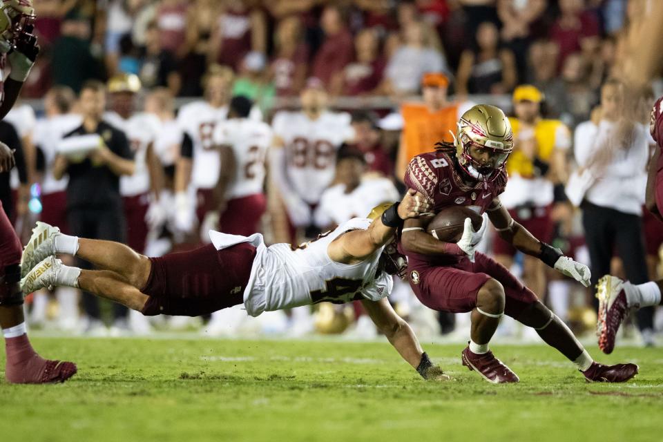 Florida State Seminoles running back Treshaun Ward (8) tries to outrun a tackle. The Florida State Seminoles defeated the Boston College Eagles 44-14 at Doak Campbell Stadium on Saturday, Sept. 24, 2022.