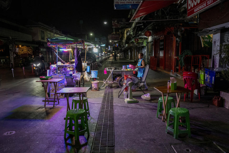 FILE - In this Jan. 4, 2021, file photo, a lone street vender waits for customers at Khao San road, a once popular hangout with bars and entertainment for locals and tourists in Bangkok, Thailand. Now, an outbreak at nightspots in the capital Bangkok has sent new infections surging, suggesting the country may have been lulled into a false sense of security before mass vaccinations begin. (AP Photo/Gemunu Amarasinghe, File)