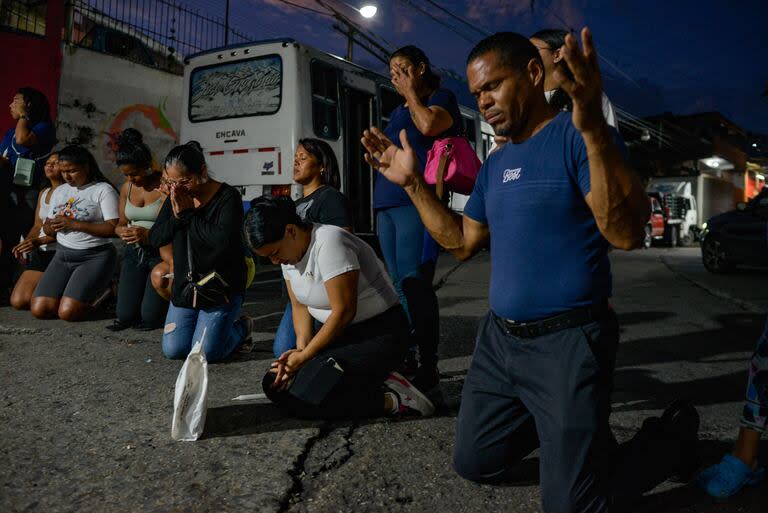 Manifestantes rezan en una vigilia previa a las movilizaciones anunciadas para el sábado en el barrio de Petare