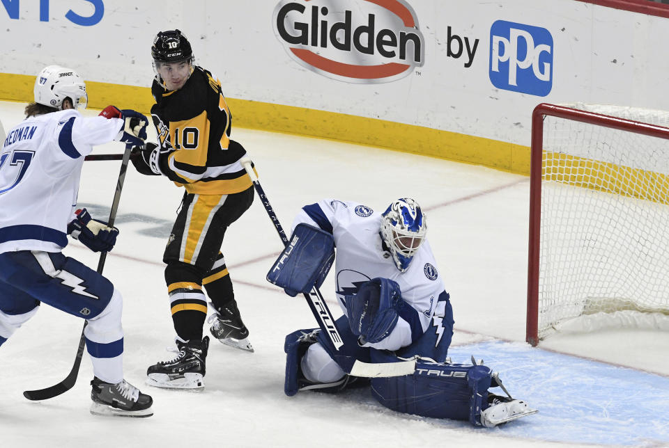 Pittsburgh Penguins left wing Drew O'Connor (10) looks back after he redirected the puck past Tampa Bay Lightning goalie Brian Elliott (1) as Lightning defenseman Victor Hedman (77) applies coverage during the first period of an NHL hockey game, Sunday, Feb. 26, 2023, in Pittsburgh. (AP Photo/Philip G. Pavely)
