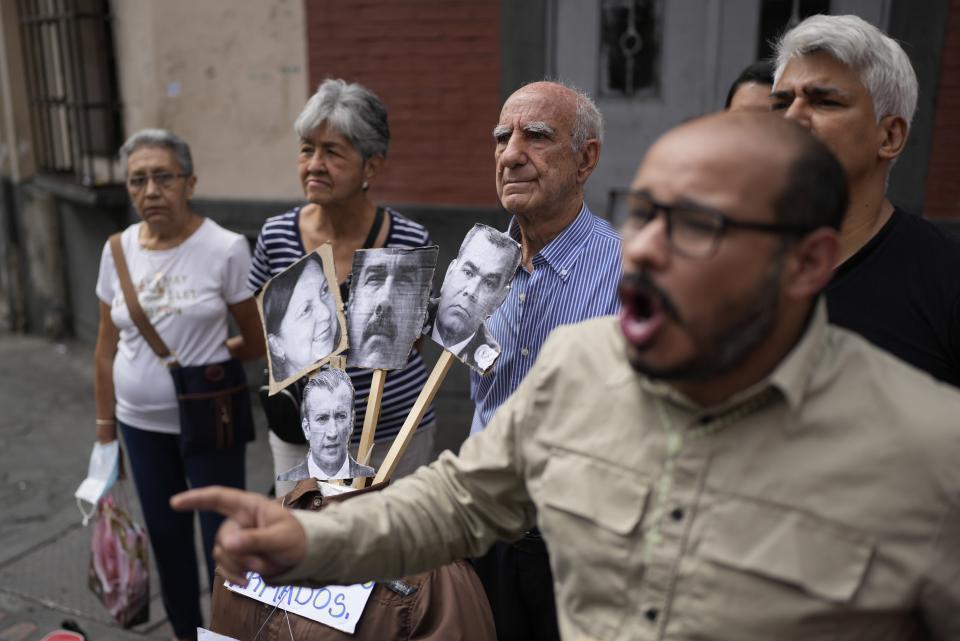 FILE - Residents surround effigies of ruling party Mayor of Caracas, Carmen Melendez, Venezuelan President Nicolás Maduro, Defense Minister Padrino Lopez and former Oil Minister Tareck El Aissami, during an Easter event known as the burning of Judas, before setting the effigies on fire in Caracas, Venezuela, on Easter Sunday, April 9, 2023. Opposition political parties encouraged voters to boycott elections for years before urging them to participate in the planned October 2023 primary election to chose a single candidate to face Maduro at the ballot box. (AP Photo/Ariana Cubillos, File)