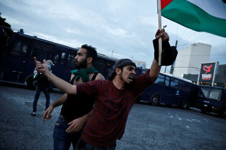 A Palestinian shouts slogans as others throw stones towards the Israeli embassy during a demonstration against the recent killings of Palestinian protesters on the Gaza-Israel border and the U.S. embassy move to Jerusalem, in Athens, Greece, May 15, 2018. REUTERS/Alkis Konstantinidis