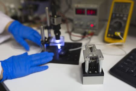 A SpacePharma employee works beside a miniature laboratory that will carry out experiments in space, in their offices in Herzliya near Tel Aviv February 24, 2015. REUTERS/Amir Cohen