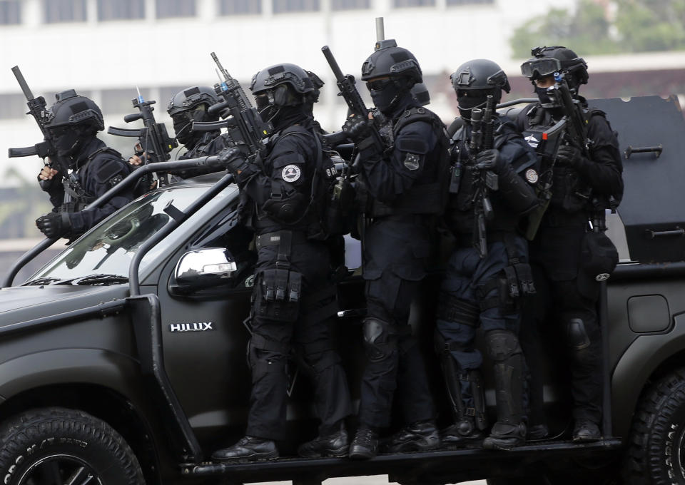 In this July 25, 2018, photo, members of joint Indonesian police and military special forces take part in an anti-terrorism drill ahead of the 2018 Asian Games in Jakarta, Indonesia. Indonesia is deploying 100,000 police and soldiers to provide security for the Asian Games, the biggest event ever held in its terror attack prone capital Jakarta, parts of which have been dramatically spruced up as the city readies to welcome tens of thousands of athletes and visitors. (AP Photo/Tatan Syuflana)