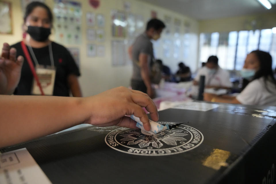 An election worker places the voting receipt inside a box at a polling center Monday, May 9, 2022 in Quezon City, Philippines. Filipinos were voting for a new president Monday, with the son of an ousted dictator and a champion of reforms and human rights as top contenders in a tenuous moment in a deeply divided Asian democracy. (AP Photo/Aaron Favila)