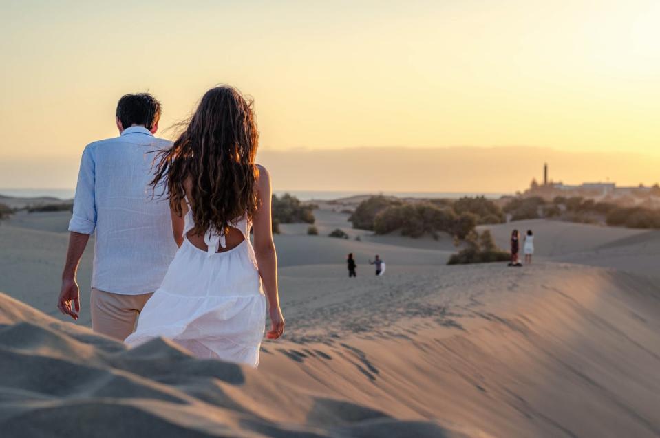 Una pareja en la playa de Maspalomas (Gran Canaria). <a href="https://www.shutterstock.com/es/image-photo/lost-sunset-on-top-sand-dunes-1858160038" rel="nofollow noopener" target="_blank" data-ylk="slk:Shutterstock / Cosmin Onofrei;elm:context_link;itc:0;sec:content-canvas" class="link ">Shutterstock / Cosmin Onofrei</a>