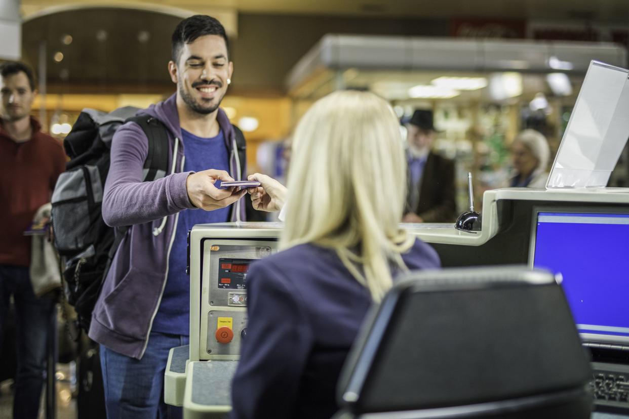 young spanish man checking in at an airport counter