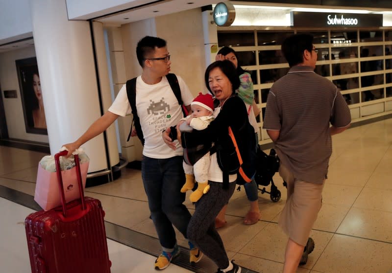 A woman runs as gates from the subway station to New Town Plaza close in Sha Tin, Hong Kong