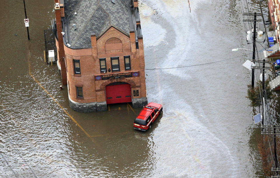 A firehouse is surrounded by floodwaters in the wake of superstorm Sandy on Tuesday, Oct. 30, 2012, in Hoboken, N.J. Sandy, the storm that made landfall Monday, caused multiple fatalities, halted mass transit and cut power to more than 6 million homes and businesses. (AP Photo/Mike Groll)