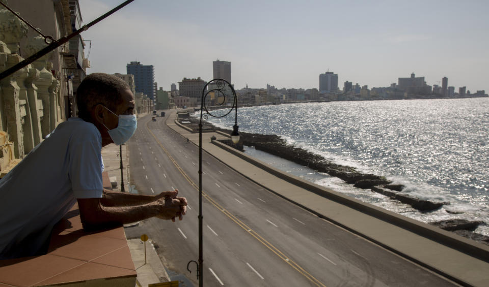 El trabajador Julio Diago mira la carretera vacía a lo largo del malecón desde el restaurante Nazdarovie, que está cerrado por la cuarentena para contener la propagación del nuevo coronavirus en La Habana, Cuba, el lunes 27 de abril de 2020. (AP Foto/Ismael Francisco)