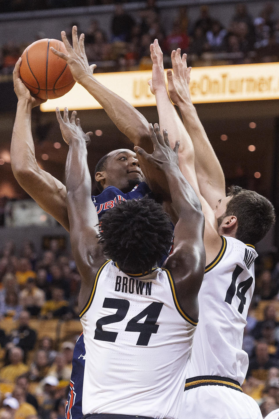 Auburn's Austin Wiley, top, shoots over Missouri's Reed Nikko, right, and Kobe Brown during the first half of an NCAA college basketball game Saturday, Feb. 15, 2020, in Columbia, Mo. (AP Photo/L.G. Patterson)