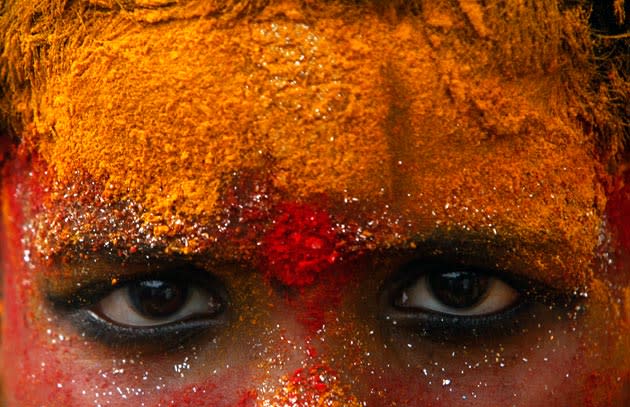 A young devotee, face smeared with turmeric powder, participates in a procession towards Golconda Fort during Bonalu festival in Hyderabad, India, Thursday, July 15, 2010. Bonalu is a month-long festival celebrated in Andhra Pradesh state and is dedicated to the Hindu Goddess of power Kali. (AP Photo/Mahesh Kumar A.)