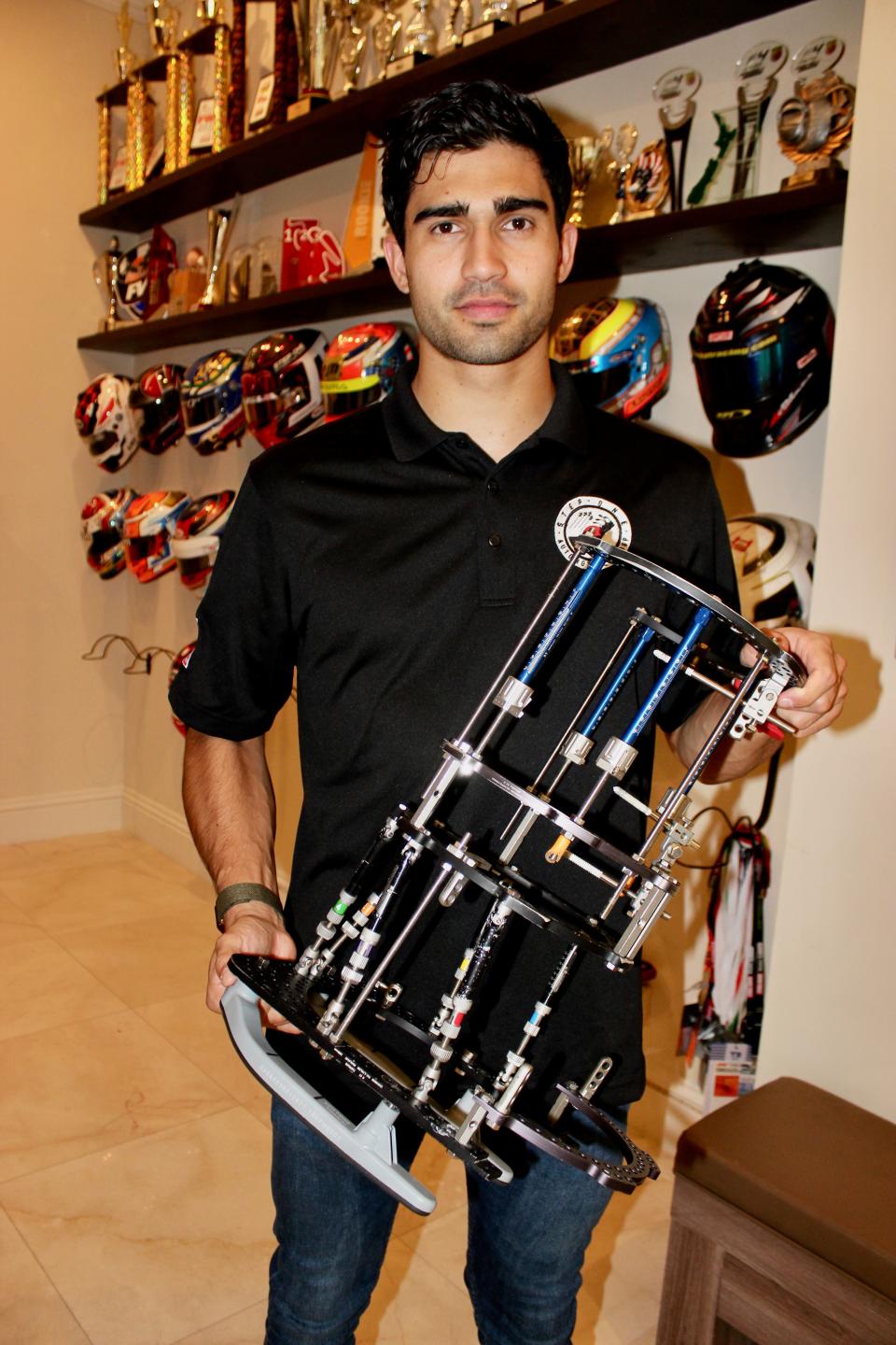 Race driver Juan Manuel Correa holds the exoskeleton he had to wear for more than three months to help his right leg heal following a crash that killed driver Anthoine Hubert in 2019.