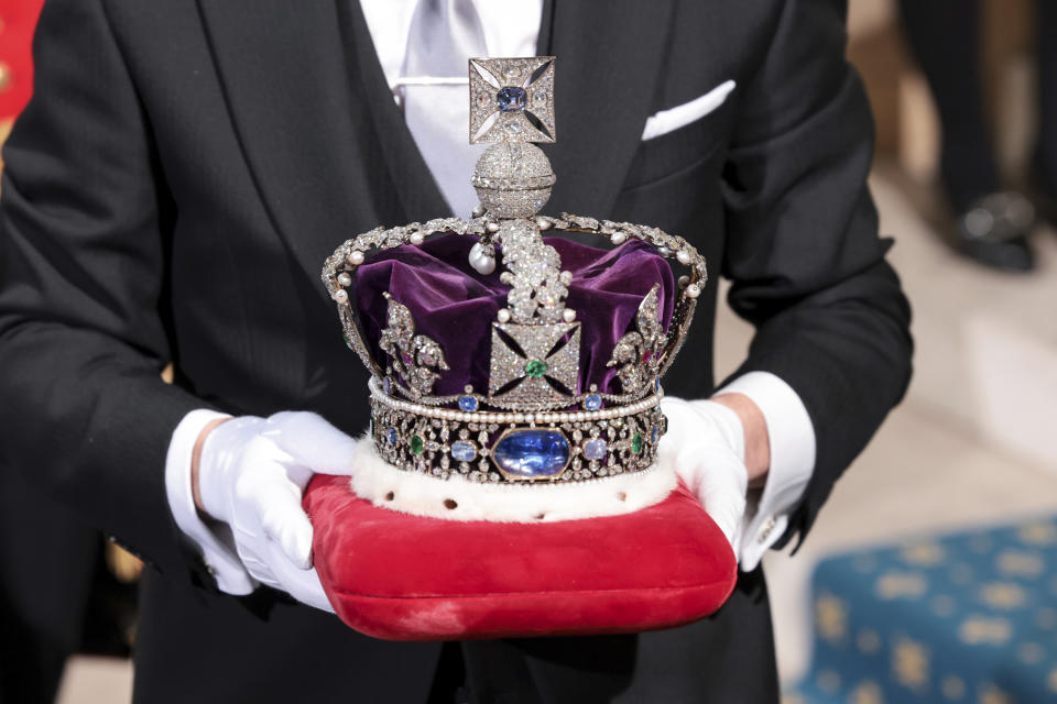 The Imperial State Crown is carried through the Sovereign's Entrance ahead of the State Opening of Parliament at Houses of Parliament, in London, Tuesday, May 10, 2022. Britain’s Parliament opens a new year-long session on Tuesday with a mix of royal pomp and raw politics, as Prime Minister Boris Johnson tries to re-energize his scandal-tarnished administration and revive the economy amid a worsening cost-of-living crisis. (Chris Jackson/Pool Photo via AP)