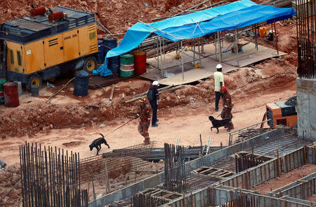 Rescue workers and sniffer dogs are seen at a construction site after it was hit by a landslide in Tanjung Bungah, a suburb of George Town, Penang, Malaysia October 21, 2017. REUTERS/Lai Seng Sin