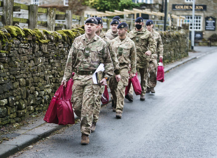 Members of the armed forces carry customer care packs, which contain amongst other items, hot water bottles, hats, blankets, gloves and thermal socks, in St John&#39;s Chapel, Weardale, County Durham, to hand to residents who have been without power for a week since Storm Arwen caused 