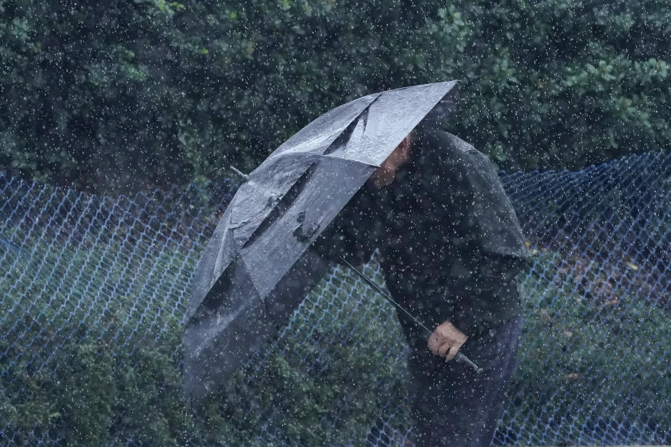 Rain falls as a pedestrian walks up a hill carrying an umbrella in San Francisco, Wednesday, Jan. 11, 2023. Storm-ravaged California is scrambling to clean up and repair widespread damage. (AP Photo/Jeff Chiu)