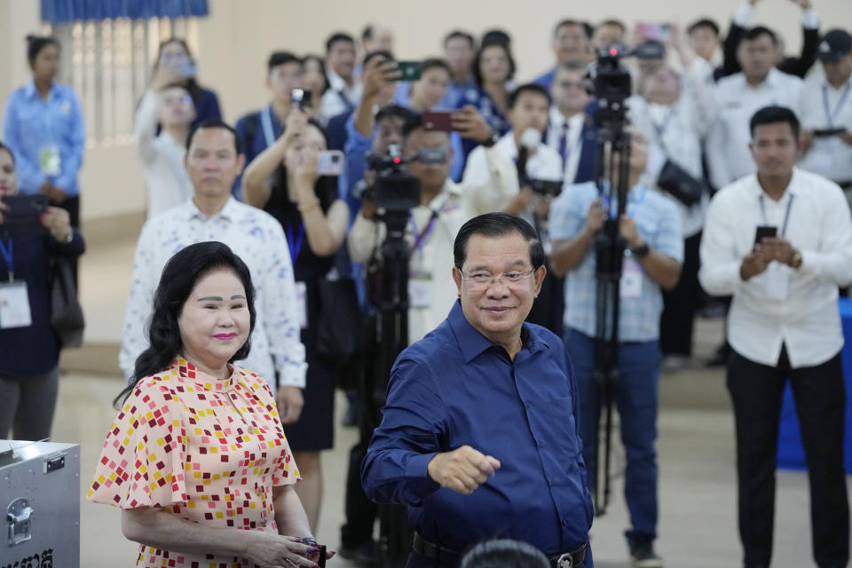 Cambodian Prime Minister Hun Sen, front right, of the Cambodian People's Party (CPP), smiles standing next to his wife Bun Rany, front left, after voting a ballot at a polling station in Takhmua in Kandal province, southeast Phnom Penh, Cambodia, Sunday, July 23, 2023. Cambodians go to the polls Sunday with incumbent Prime Minister Hun Sen and his party all but assured a landslide victory thanks to the effective suppression and intimidation of any real opposition that critics say has made a farce of democracy in the Southeast Asian nation. (AP Photo/Heng Sinith)