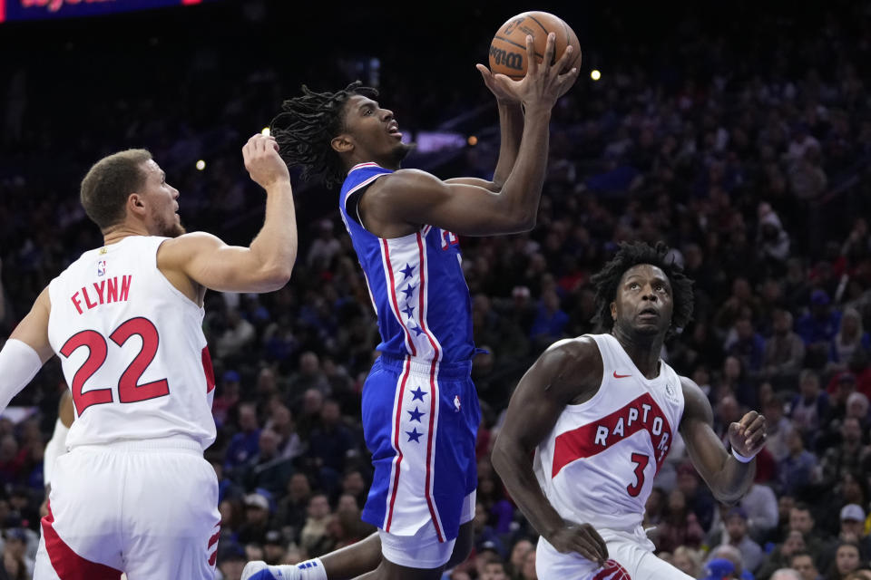 Philadelphia 76ers' Tyrese Maxey, center, goes up for a shot between Toronto Raptors' Malachi Flynn, left, and O.G. Anunoby during the first half of an NBA basketball game, Thursday, Nov. 2, 2023, in Philadelphia. (AP Photo/Matt Slocum)