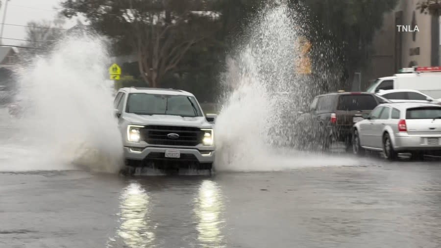 A truck drives on a flooded road in Ventura County.