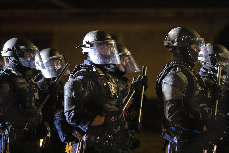 Portland police take control of the streets after making arrests on the scene of the nightly protests at a Portland police precinct on Sunday, Aug. 30, 2020 in Portland, Ore. Oregon State Police will return to Portland to help local authorities after the fatal shooting of a man following clashes between President Donald Trump supporters and counter-protesters that led to an argument between the president and the city's mayor over who was to blame for the violence. (AP Photo/Paula Bronstein)