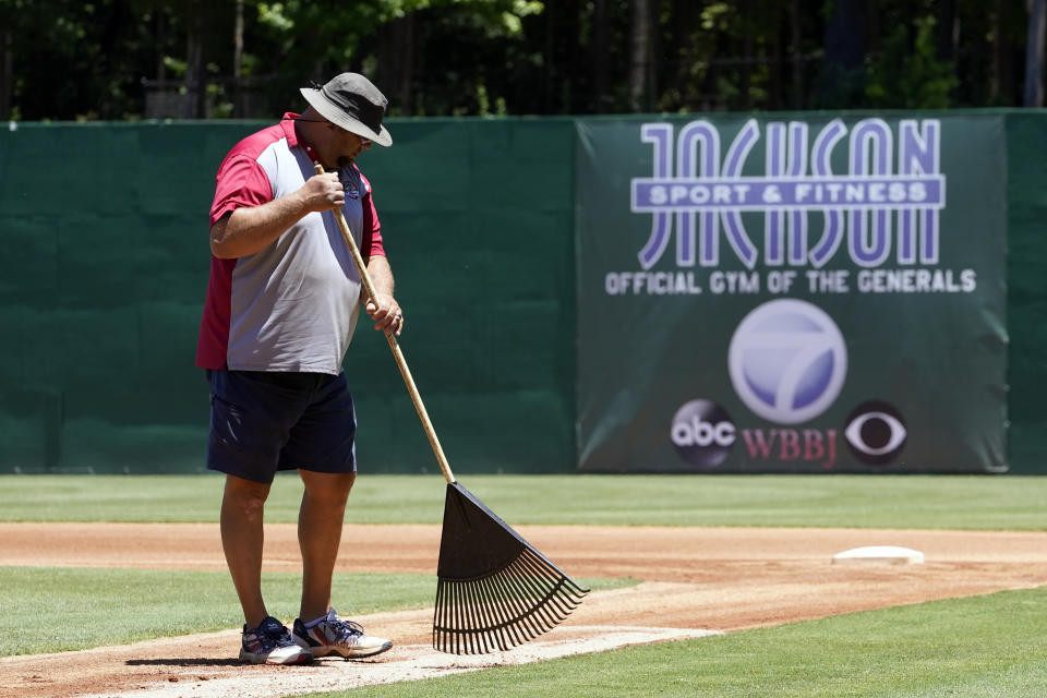 Matt Malone, turf manager as well as director of stadium operations at The Ballpark at Jackson, grooms the infield before a home game for the Winnipeg Goldeyes of the American Association, on Tuesday, June 22, 2021, in Jackson, Tenn. When Major League Baseball stripped 40 teams of their affiliation in a drastic shakeup of the minor leagues this winter, Jackson lost the Jackson Generals, the Double-A affiliate of the Arizona Diamondbacks. The Goldeyes are playing their home games in Jackson due to COVID-19 restrictions. (AP Photo/Mark Humphrey)