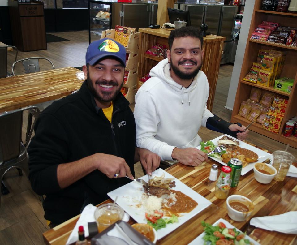 Samuel Gomes, who comes all the way from Saugus, and Arthur Pechin from Haliax, sit down to a meal at the Taste of Brazil in Brockton on Thursday, March 16, 2023.