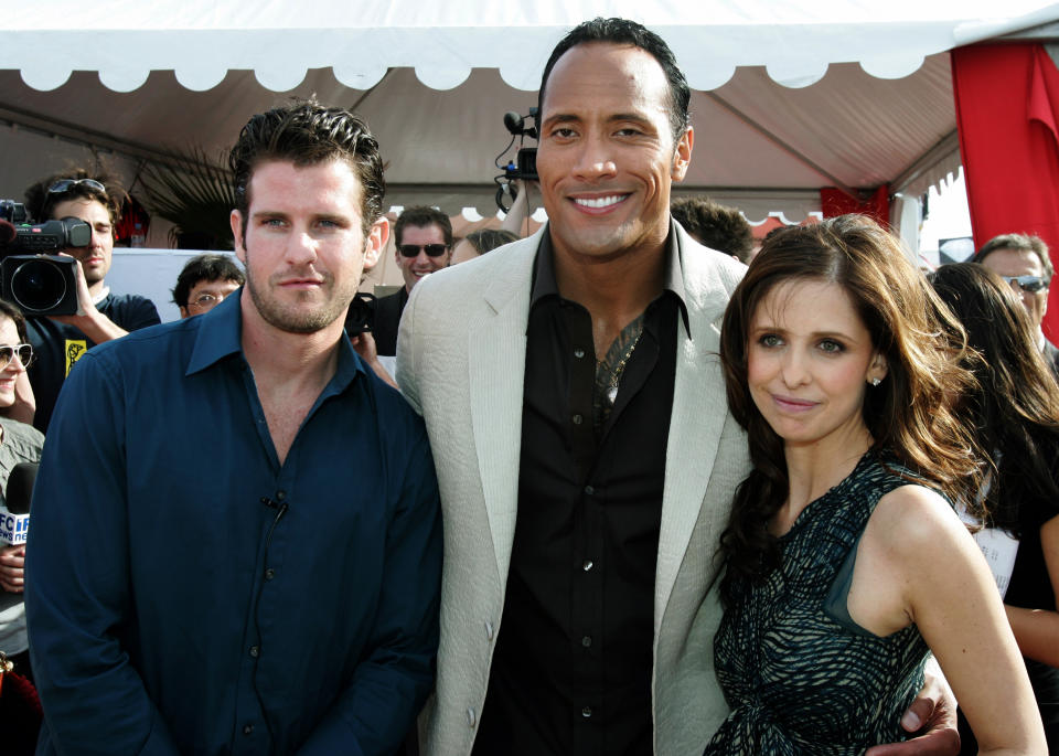 U.S. director Richard Kelly (L) poses with cast members U.S. actor Dwayne 'The Rock' Johnson (C) and U.S actress Sarah Michelle Gellar at a cocktail party for the director's in competition film 'Southland Tales' at the 59th Cannes Film Festival May 21, 2006.      REUTERS/Tom Boland