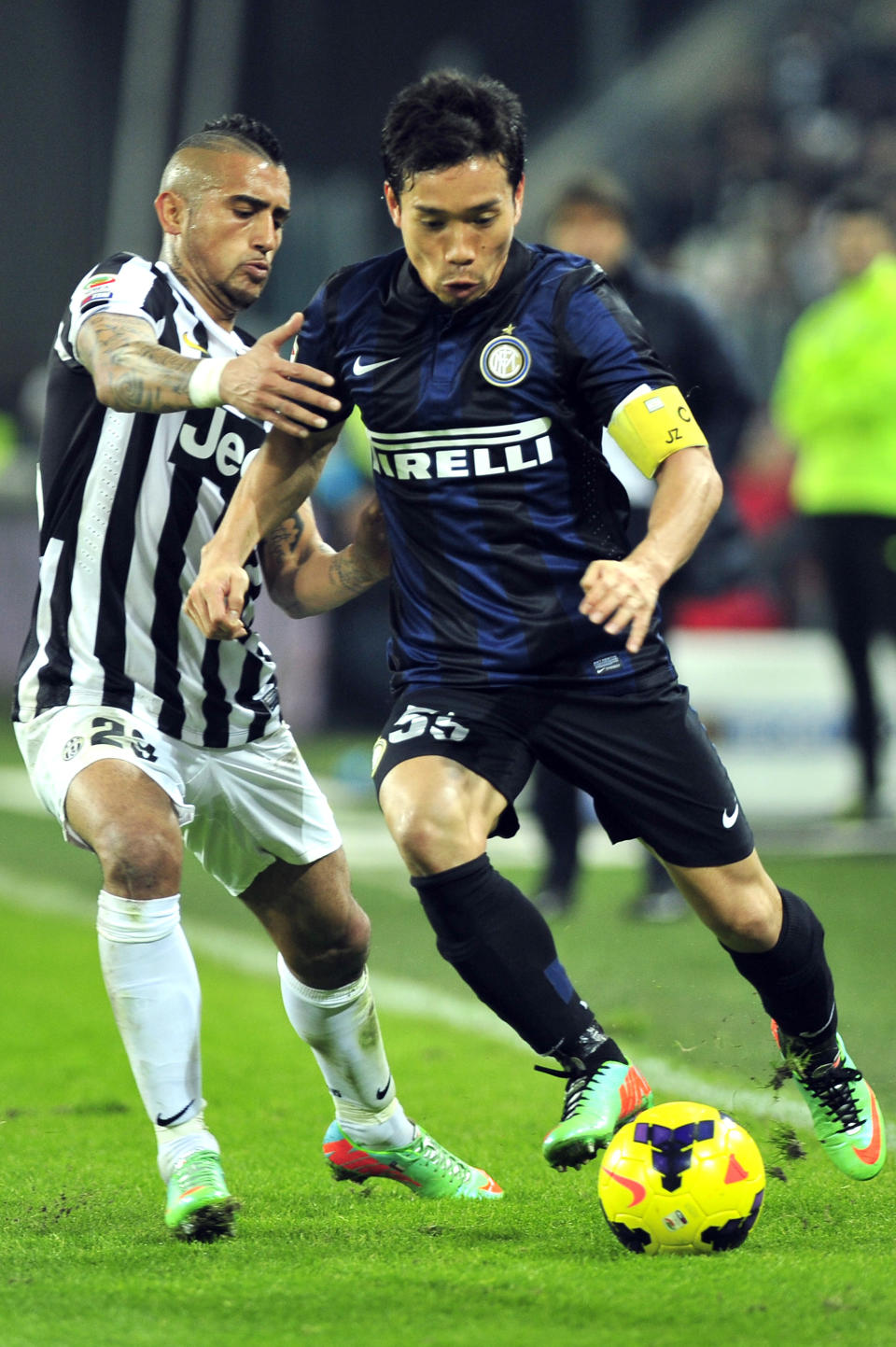 Inter Milan defender Yuto Nagatomo, of Japan, challenges the ball with Juventus midfielder Arturo Vidal, of Chile, during a Serie A soccer match between Juventus and Inter Milan at the Juventus stadium, in Turin, Italy, Sunday, Feb. 2, 2014. (AP Photo/Massimo Pinca)