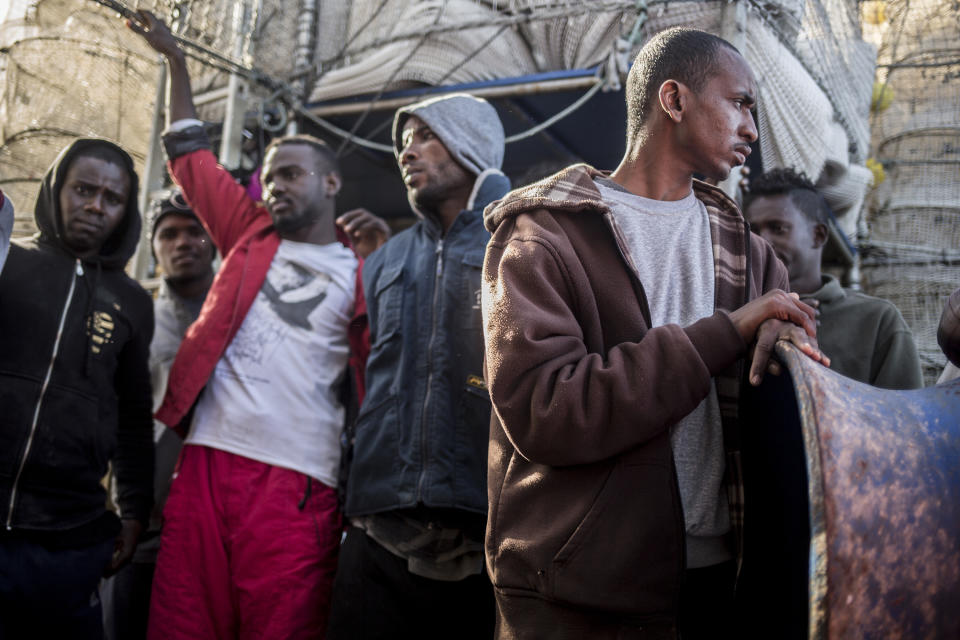 In this photo taken on Saturday, Nov. 24, 2018 photo, Migrants from Somalia, Nigeria, Sudan, Senegal and Egypt stand on the deck of Nuestra Madre de Loreto, a Spanish fishing vessel, after being rescued two days ago off the Libyan coast. The Open Arms assisted migrants medically and provided them with food, blankets and clothes. (AP Photo/Javier Fergo)