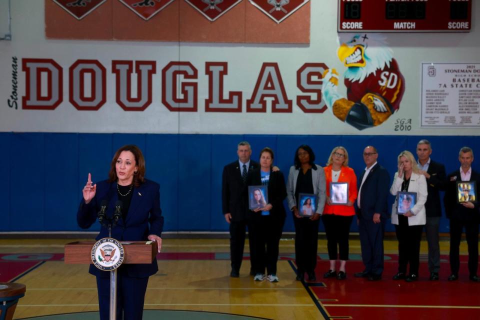 PHOTO: Vice President Kamala Harris speaks to the media as family members hold portraits of their loved ones who were killed during the 2018 shooting at Marjory Stoneman Douglas High School in Parkland, FL, March 23, 2024. (Joe Raedle/Getty Images)