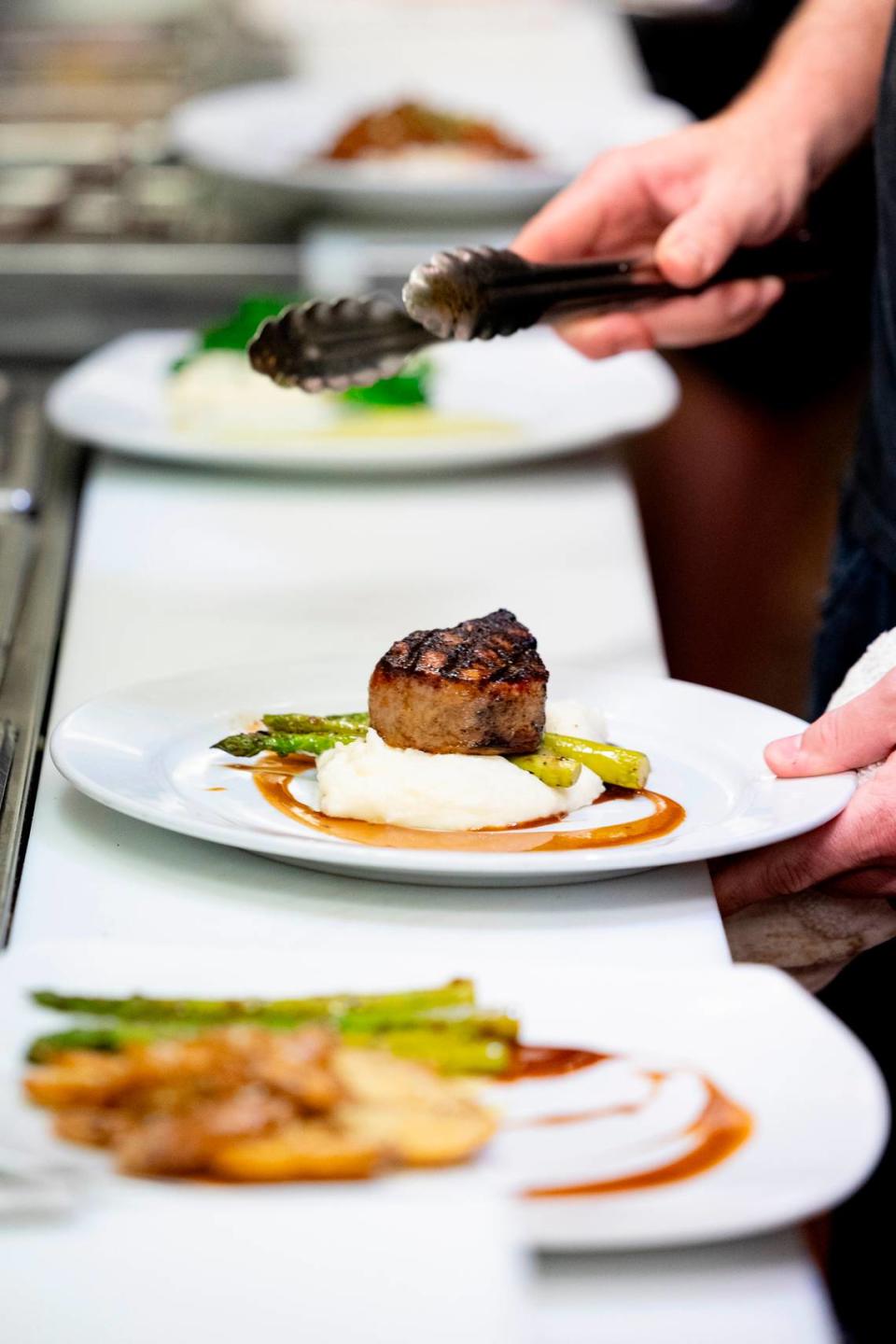 Daniel Whalen plates a dish at Saluda’s Restaurant on Thursday, Feb. 8, 2024.