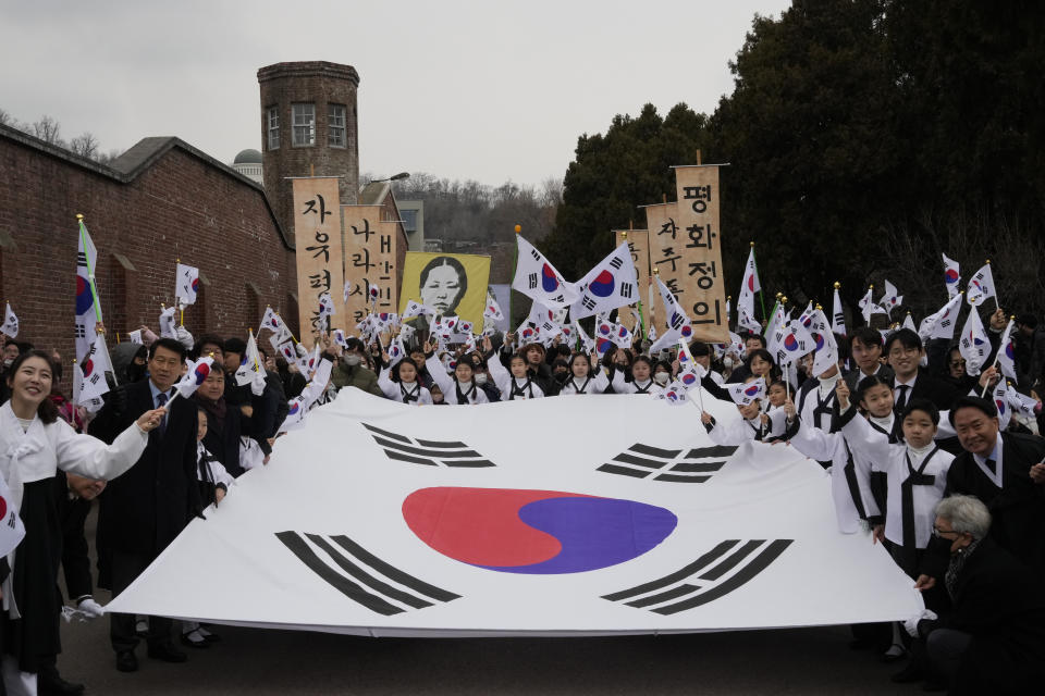 South Koreans wave national flags as they march during a ceremony to celebrate the March First Independence Movement Day, the anniversary of the 1919 uprising against Japanese colonial rule, in Seoul, South Korea, Wednesday, March 1, 2023. (AP Photo/Ahn Young-joon)