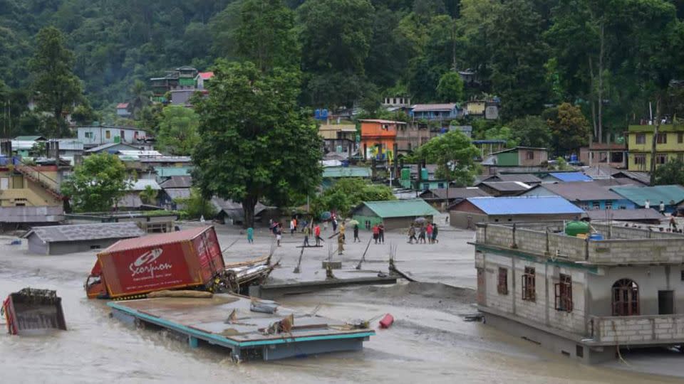 A vehicle lies on top of a submerged building after flash floods triggered by a sudden heavy rainfall swamped the Rangpo town in Sikkim, India, Oct. 5, 2023.  - Prakash Adhikari/AP