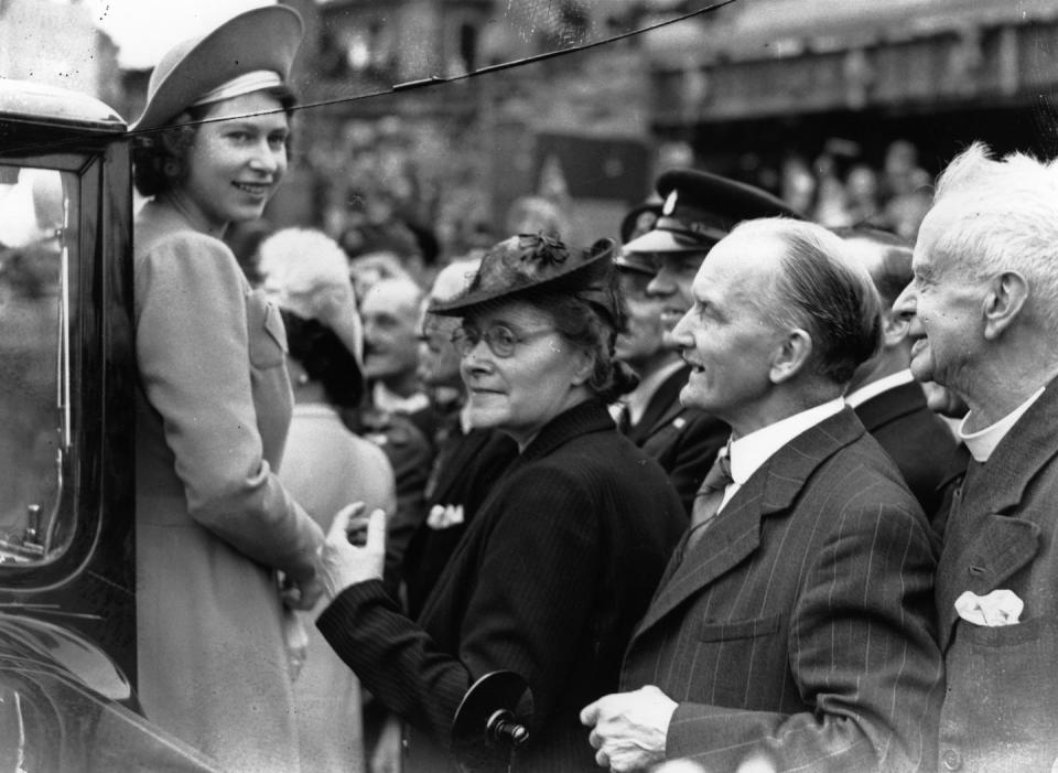 <p>The day after V-E Day, Princess Elizabeth, who worked as a mechanic during the war, greets crowds as she tours London's West End. </p>