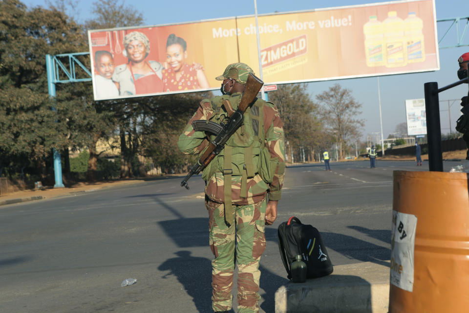 An armed soldier stands on a deserted street in Harare, Friday, July, 31, 2020. Zimbabwe's capital, Harare, was deserted Friday, as security agents vigorously enforced the country's lockdown amidst planned protests. Police and soldiers manned checkpoints and ordered people seeking to get into the city for work and other chores to return home. (AP Photo/Tsvangirayi Mukwazhi)